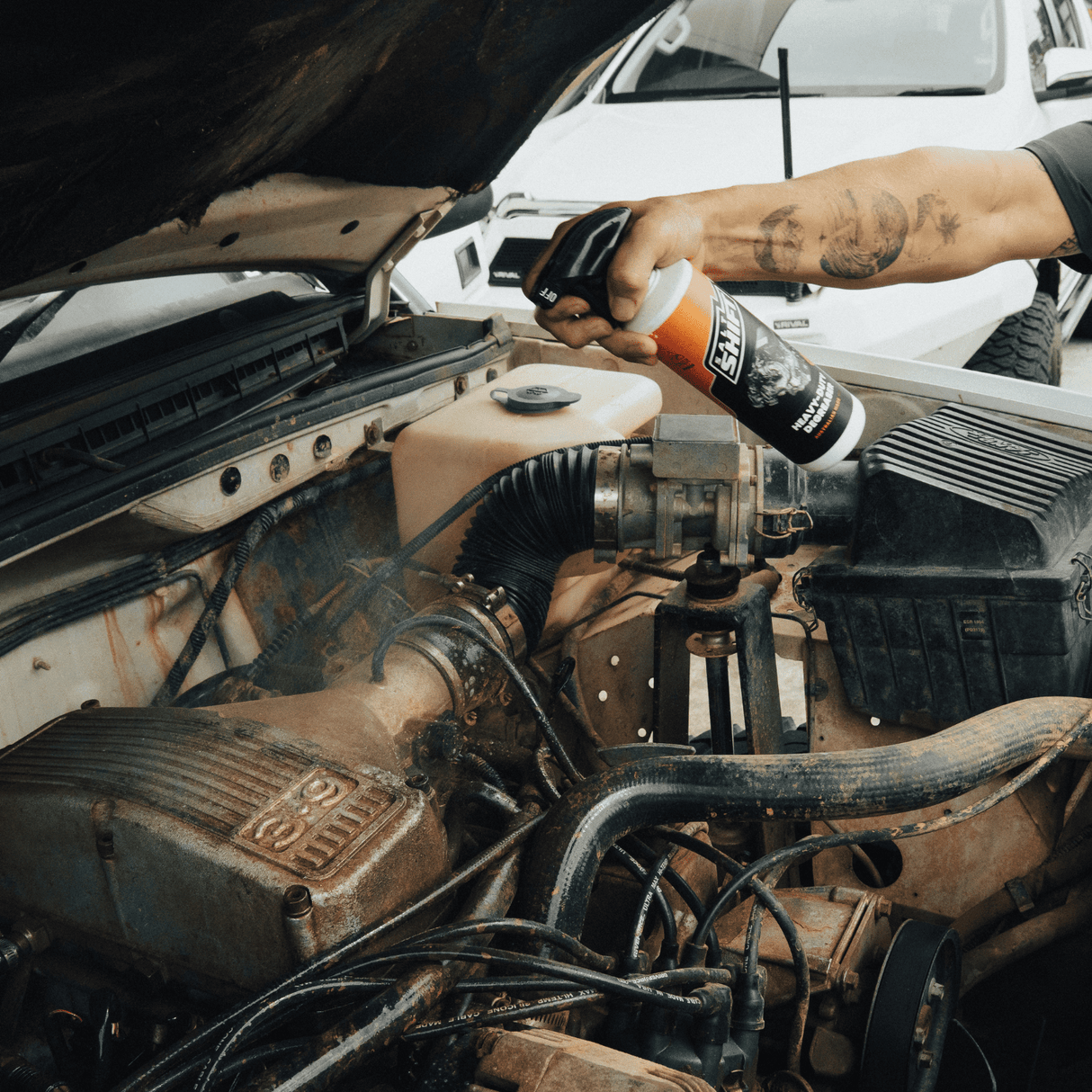 Salt Shift Heavy-Duty Degreaser being sprayed on a dirty car engine to remove grease, grime, and restore cleanliness.