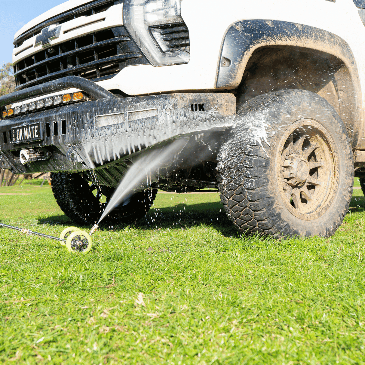 High-pressure underbody wash cleaning a 4x4 vehicle, removing dirt and grime for off-road maintenance and protection.